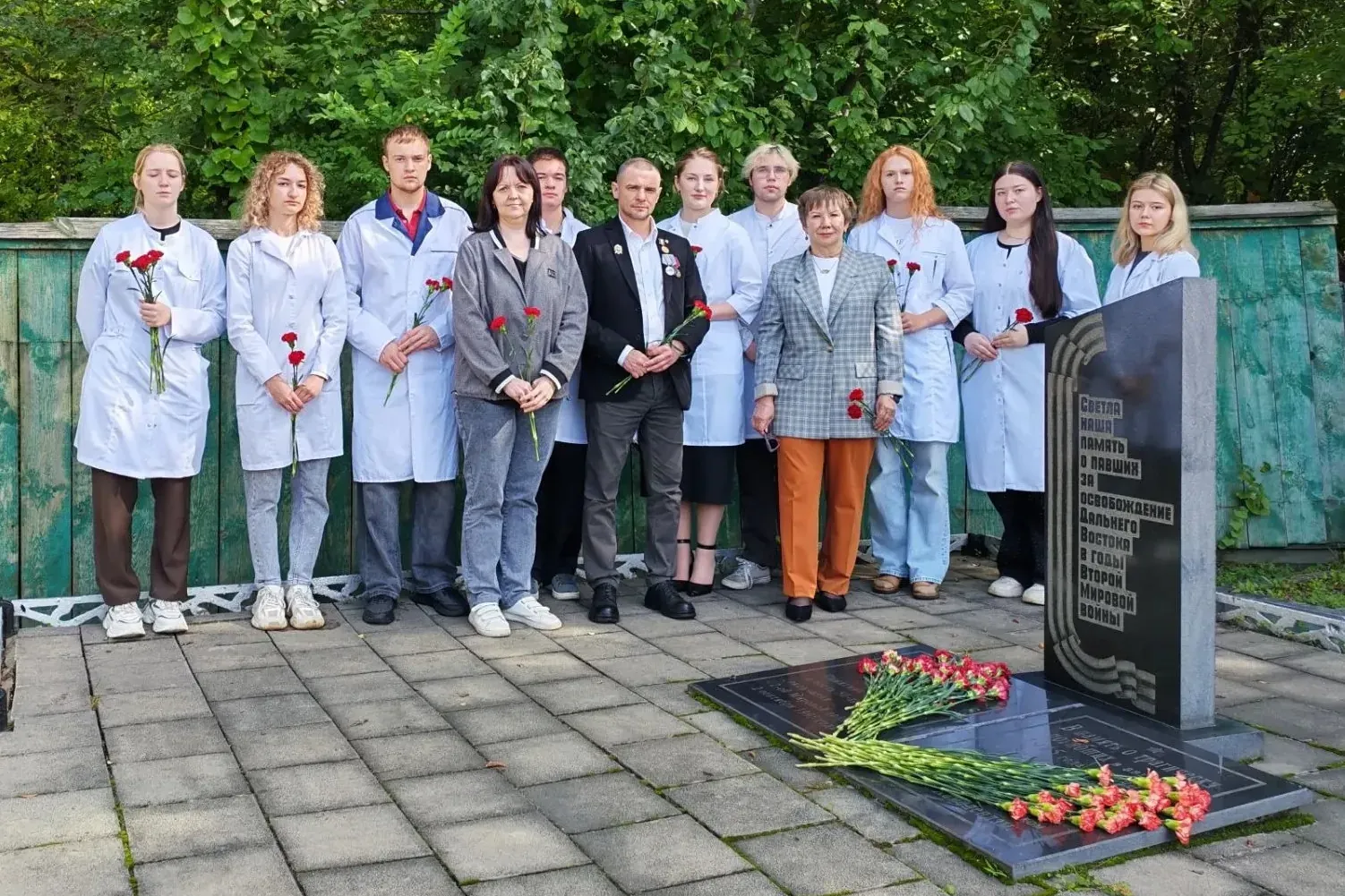Students laying carnations at military doctors memorial