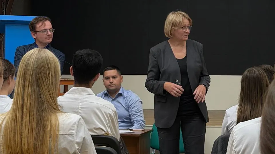 Student researchers and academic leaders at a university meeting